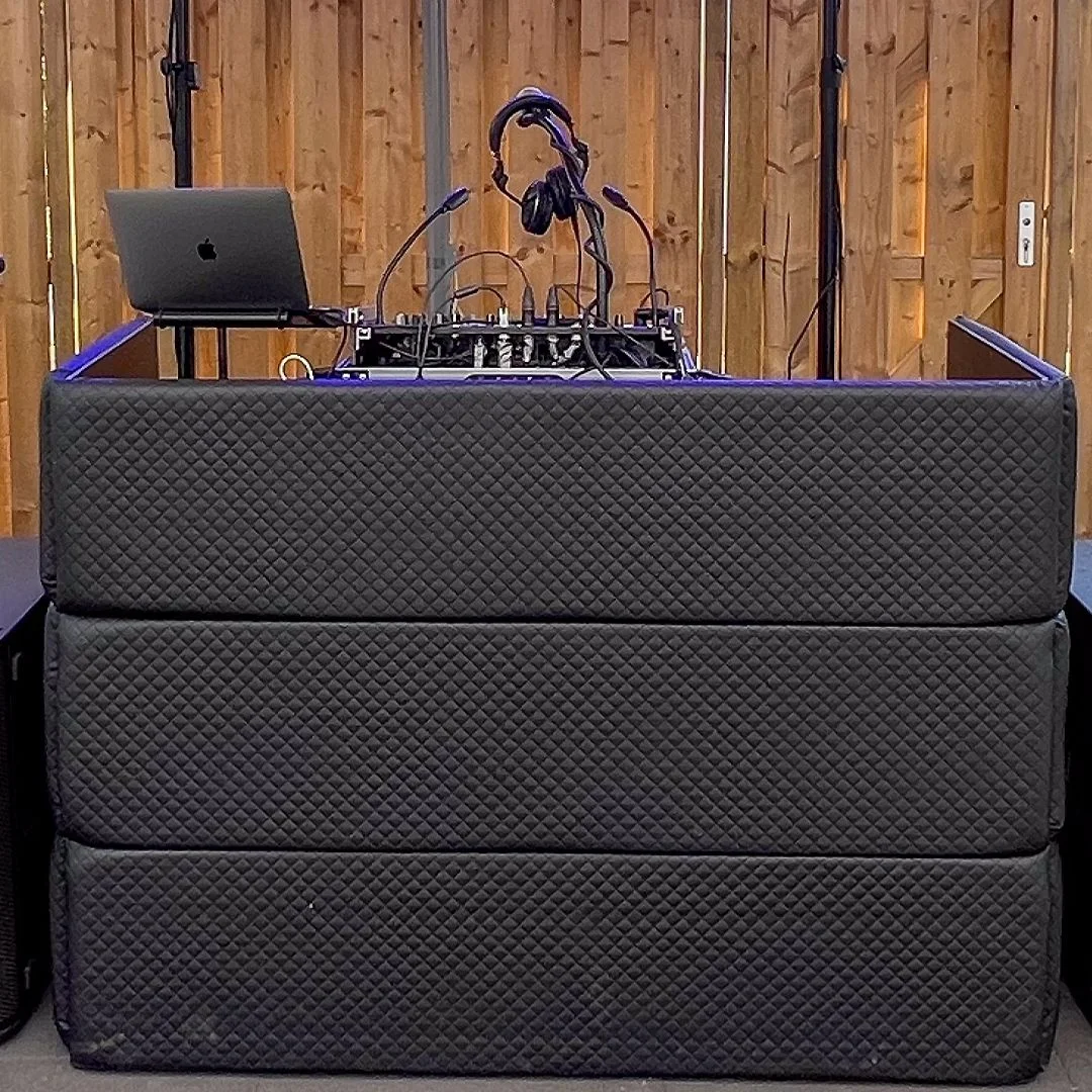DJ-booth met lichtshow op een volle dansvloer tijdens een feest